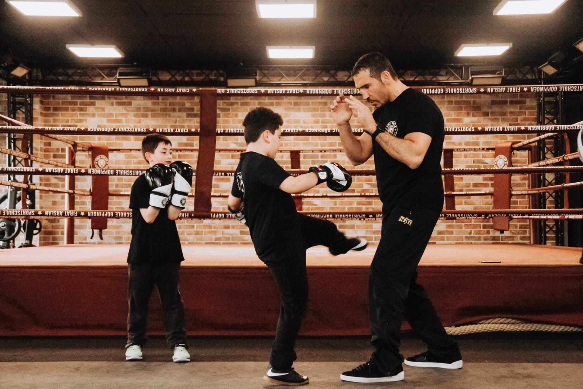Trainer beim Pratzentraining mit Kindern