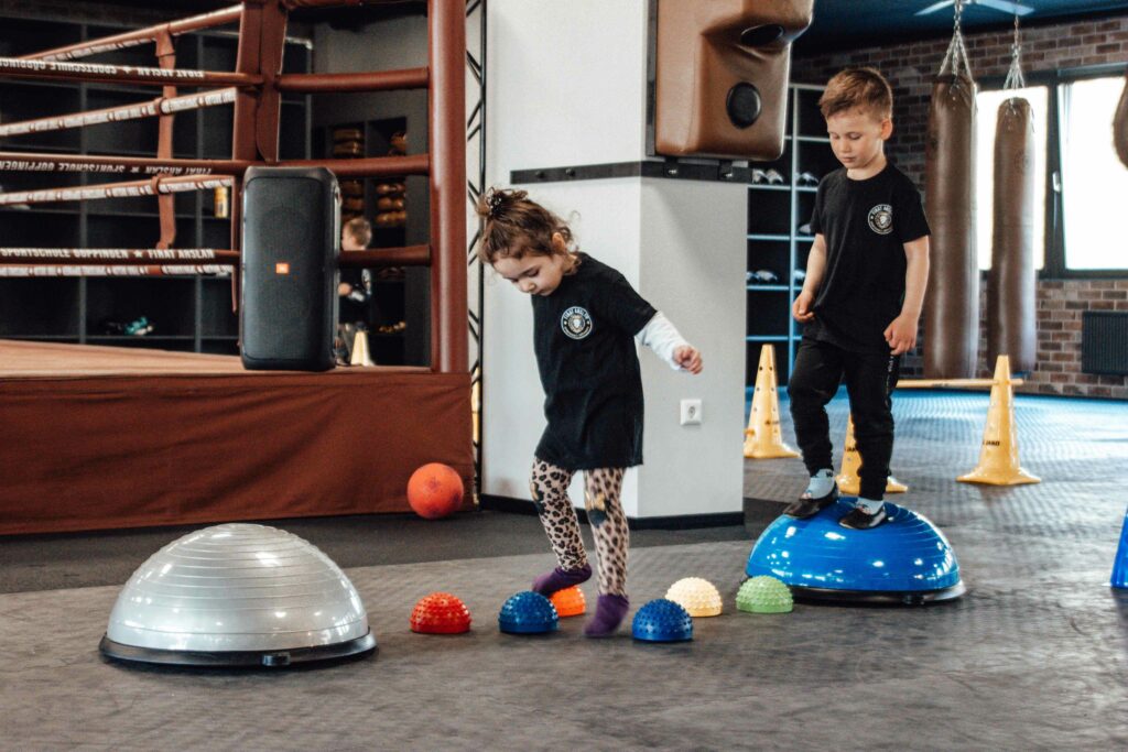 Zwei Kinder spielen in einer Boxhalle