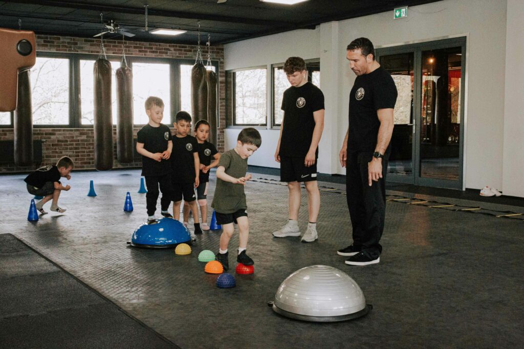 Kinder üben die Balance mit Trainer Firat