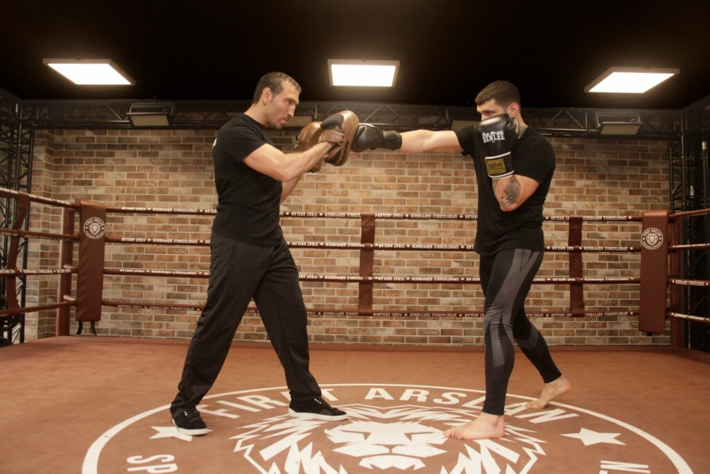 Mann schlägt beim Kickboxtrainer